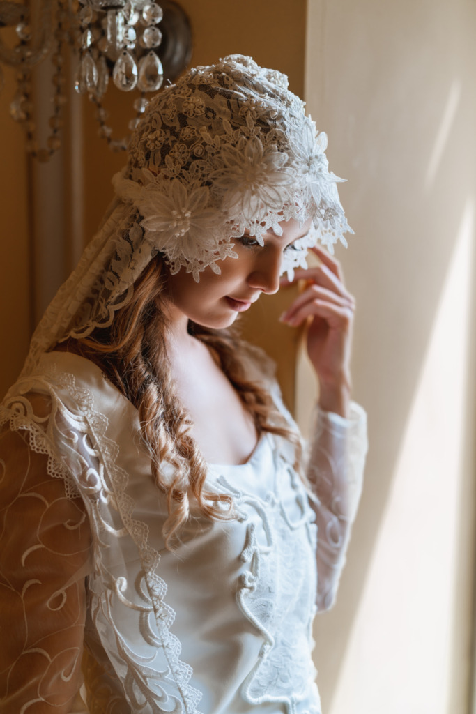 Closeup of a model in a lacy white veil and bodice from a replica of a wedding dress from Star Wars: Attack of the Clones. 