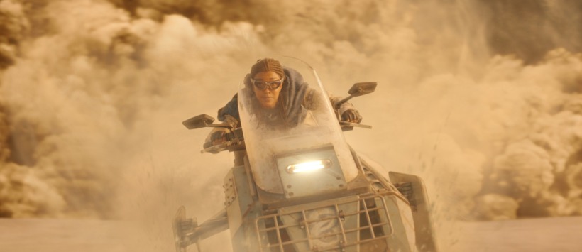 Sonequa Martin-Green as Captain Michael Burnham from Star Trek Discovery in action on a mobile vehicle being chased by a cloud of dust