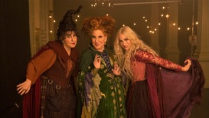 Kathy Najimy, Bette Midler, and Sarah Jessica Parker pose in their witch costumes in a still from Hocus Pocus 2. 