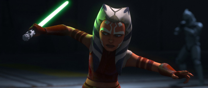 a younger Ahsoka Tano prepares to train in "Tales of the Jedi" with one green lightsaber drawn and activated