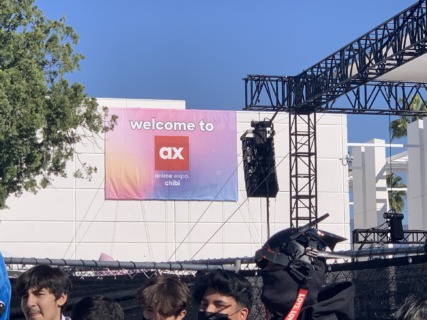 anime expo chibi welcome sign hanging on a white all outside of the convention center