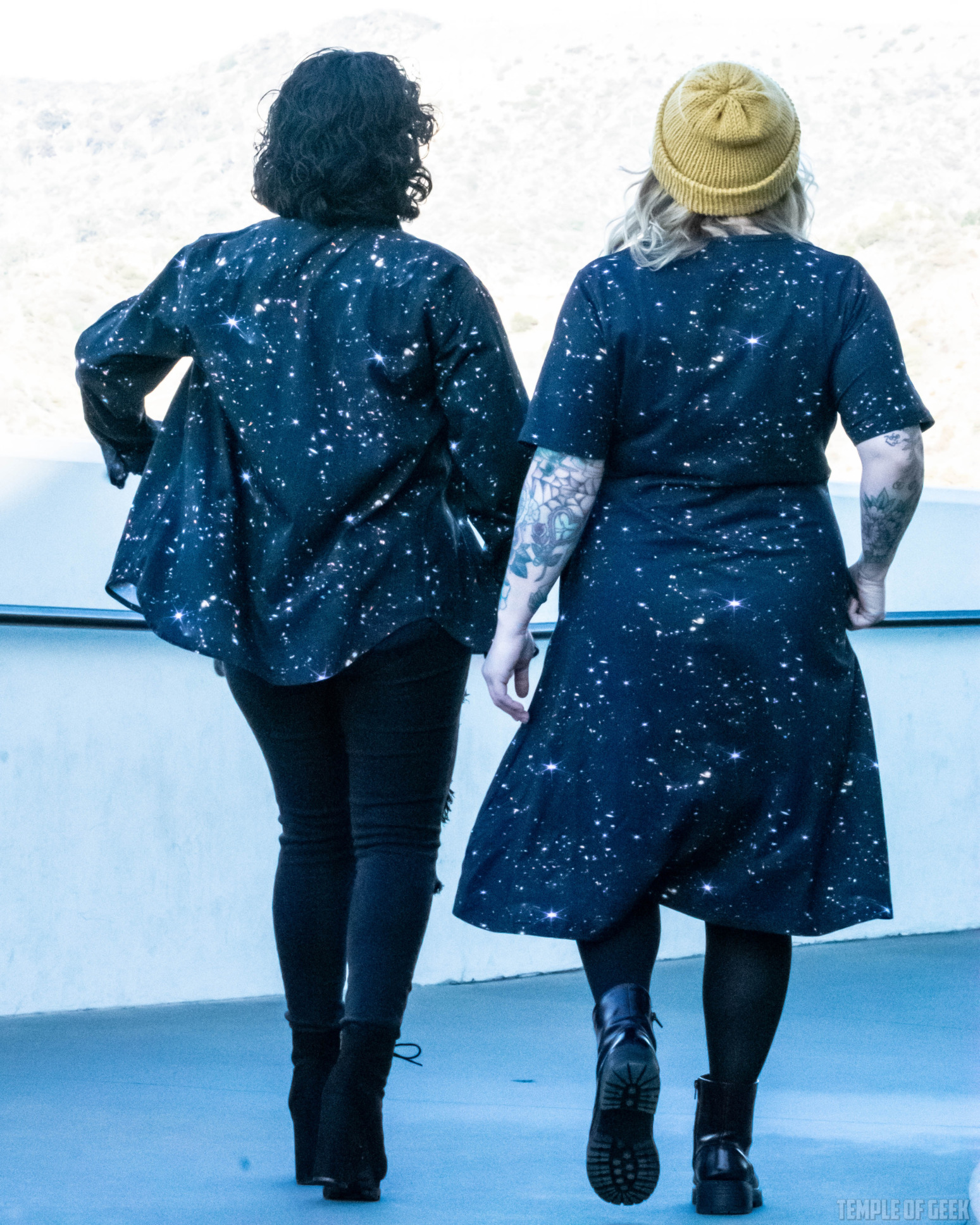 Two models are seen from the back, posing at Griffith Observatory, wearing space-themed clothes from Svaha.