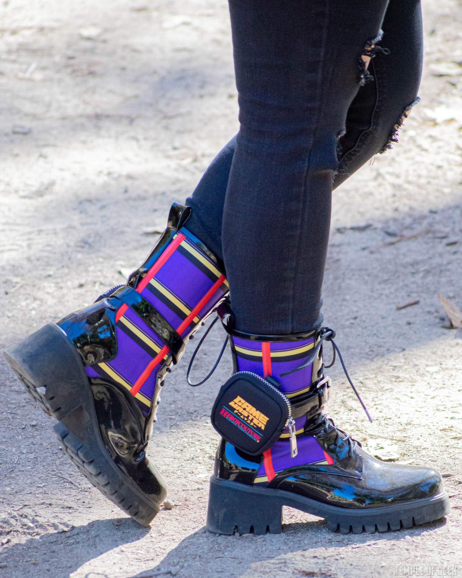 Closeup of black and plaid boots with a little utility belt and pouch at the ankle.