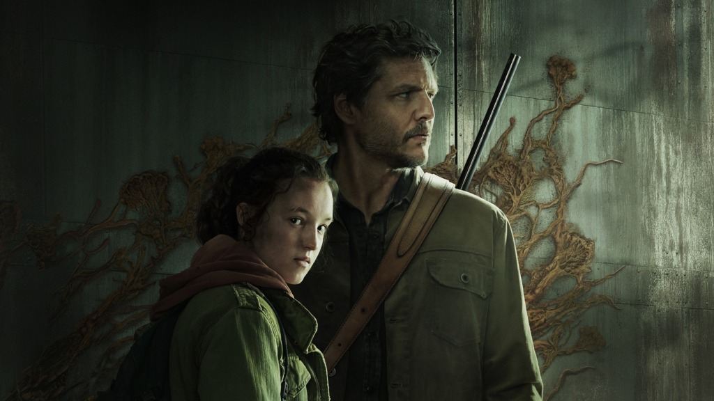 Bella Ramsey as Ellie Williams and Pedro Pascal as Joel Miller from The Last of Us stand before a dark wall covered in cordycep fungi. Ellie looks toward the viewer while Joel looks off to the side.