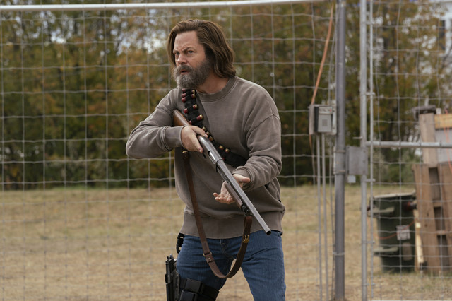 Bill (Nick Offerman) stands in front of a gate holding a shot gun in The Last of Us Episode Three (HBO).