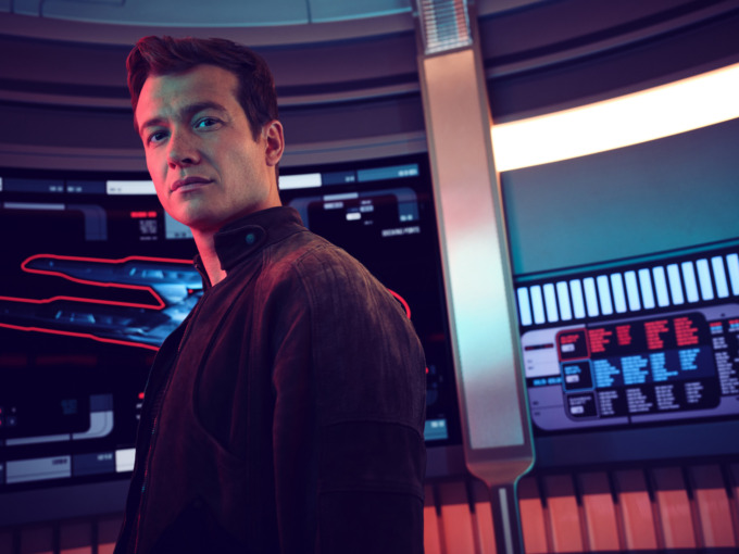 Ed Speelers as Jack Crusher posing in a starship surrounded by multiple panels and displays of a starship. Star Trek: Picard season 3. 