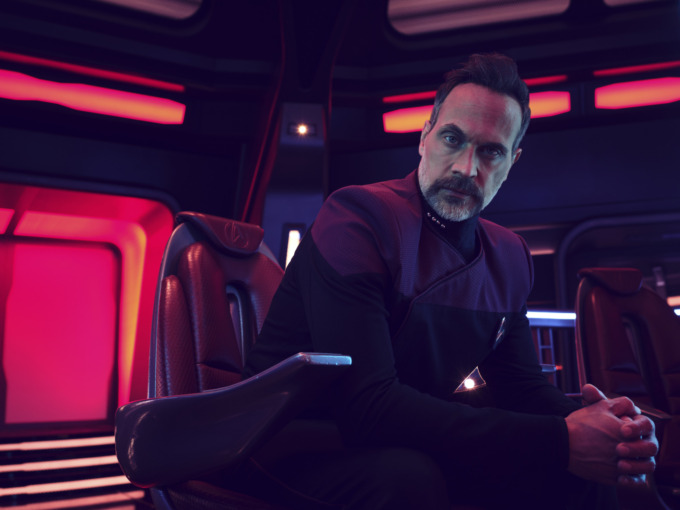 Todd Stashwick as Captain Liam Shaw sitting on the Captain's chair of a starship