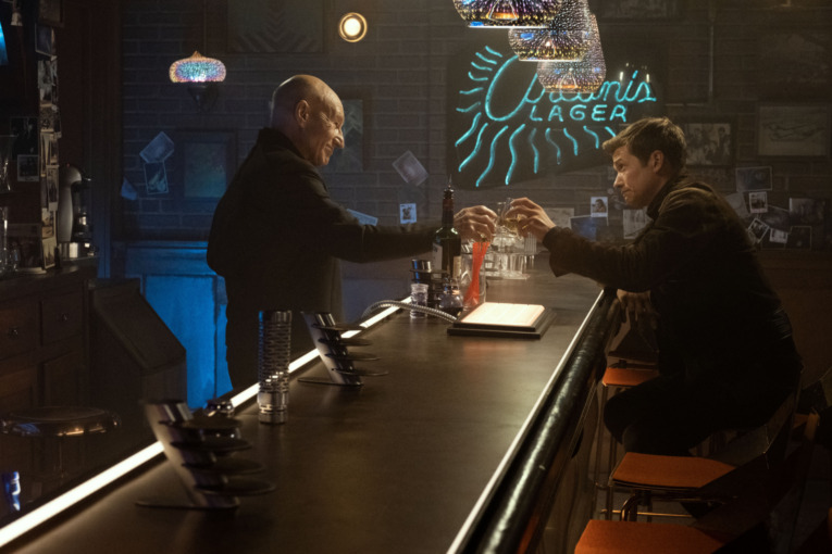 Patrick Stewart as Picard toasts a drink with Ed Speleers as Jack Crusher in the 10 Forward Bar in Star Trek Picard episode 3-04 "No Win Scenario"