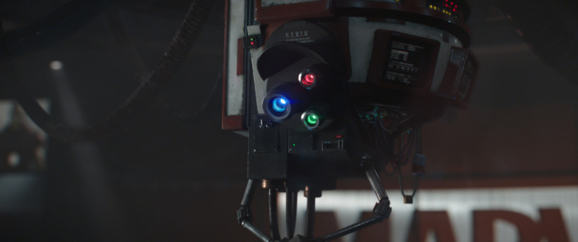 K.E.V.I.N, a robot with red, blue, and green lights hovers in front of a screen displaying the Marvel Studios logo