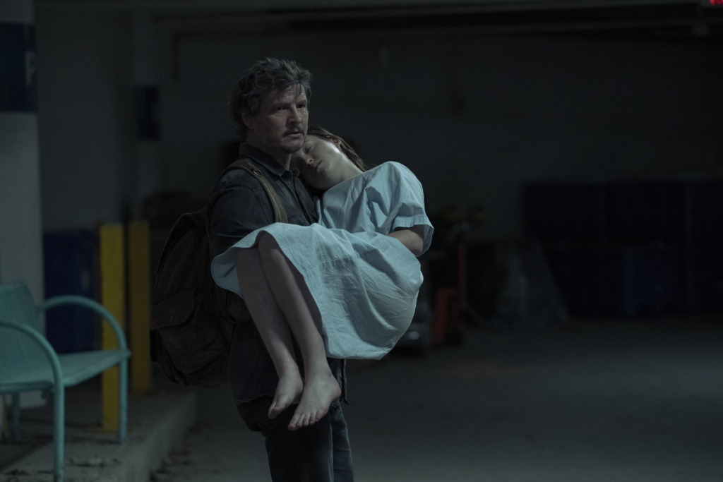 Joel (Pedro Pascal) carries Ellie (Bella Ramsey) through the hospital to escape