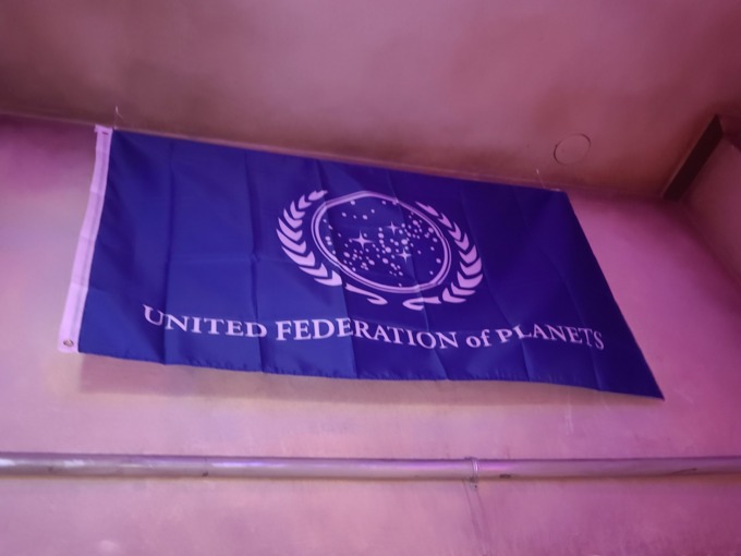 United Federation of Planets flag on display at Star Trek: Strange New Worlds Trivia Night at Scum and Villainy bar.