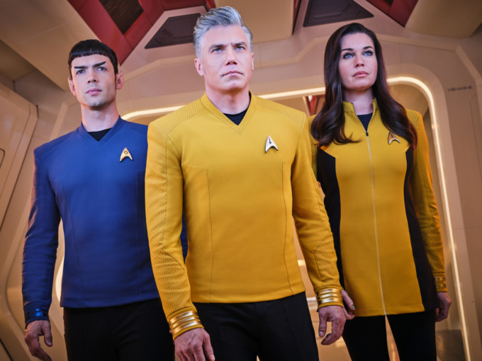 From Left to Right: Ethan Peck as Spock, Anson Mount as Pike and Rebecca Romijn as Una of the Paramount+ original series STAR TREK: STRANGE NEW WORLDS standing beside each other in one of the corridors of the USS Enterprise