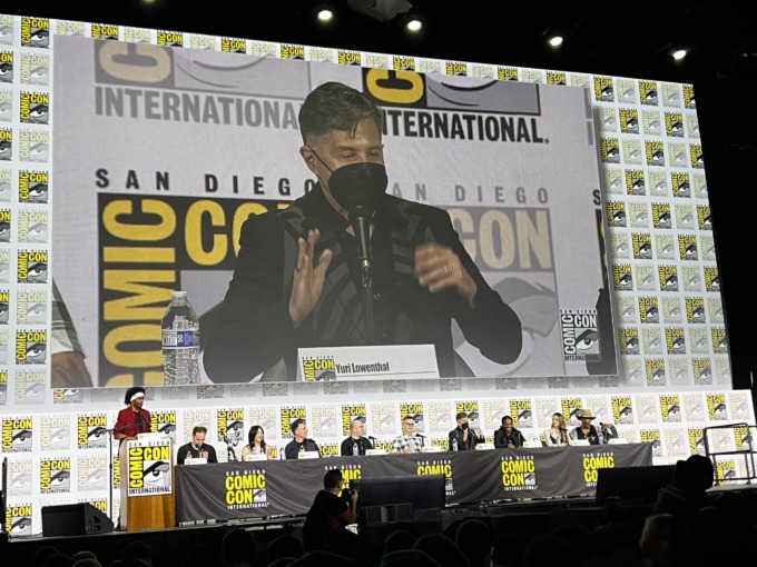 Yuri Lowenthal, dressed in a black Venom-inspired jacket and a black KN95 style face mask, attends the Spider-Man 2 SDCC panel