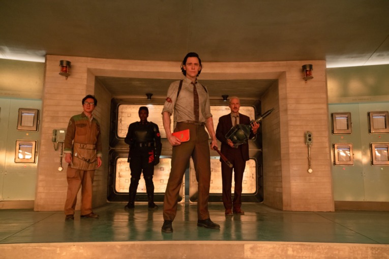 OB, B-15, Loki, and Mobius stand in an important room in the TVA. Loki is holding a copy of the TVA Guidebook and a pruning rod.