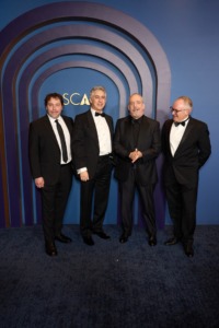 Picture of four men in suits standing together. 