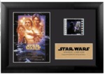 A picture of a framed poster of Star Wars: A New Hope, a cell from the movie of Darth Vader, and a gold plaque