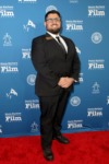 man in suit poses on red carpet