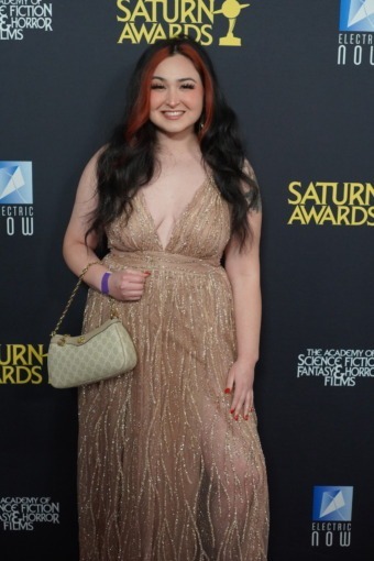 Woman in dress poses on red carpet