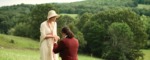 Picture of a man kneeling in front of a woman on a hill