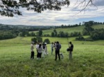 Picture of a small film crew on a grassy hill