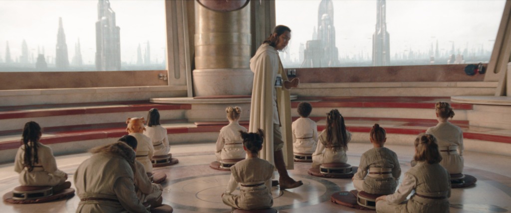 A Jedi Master walks among a group of Younglings who are meditating in the Jedi Temple.