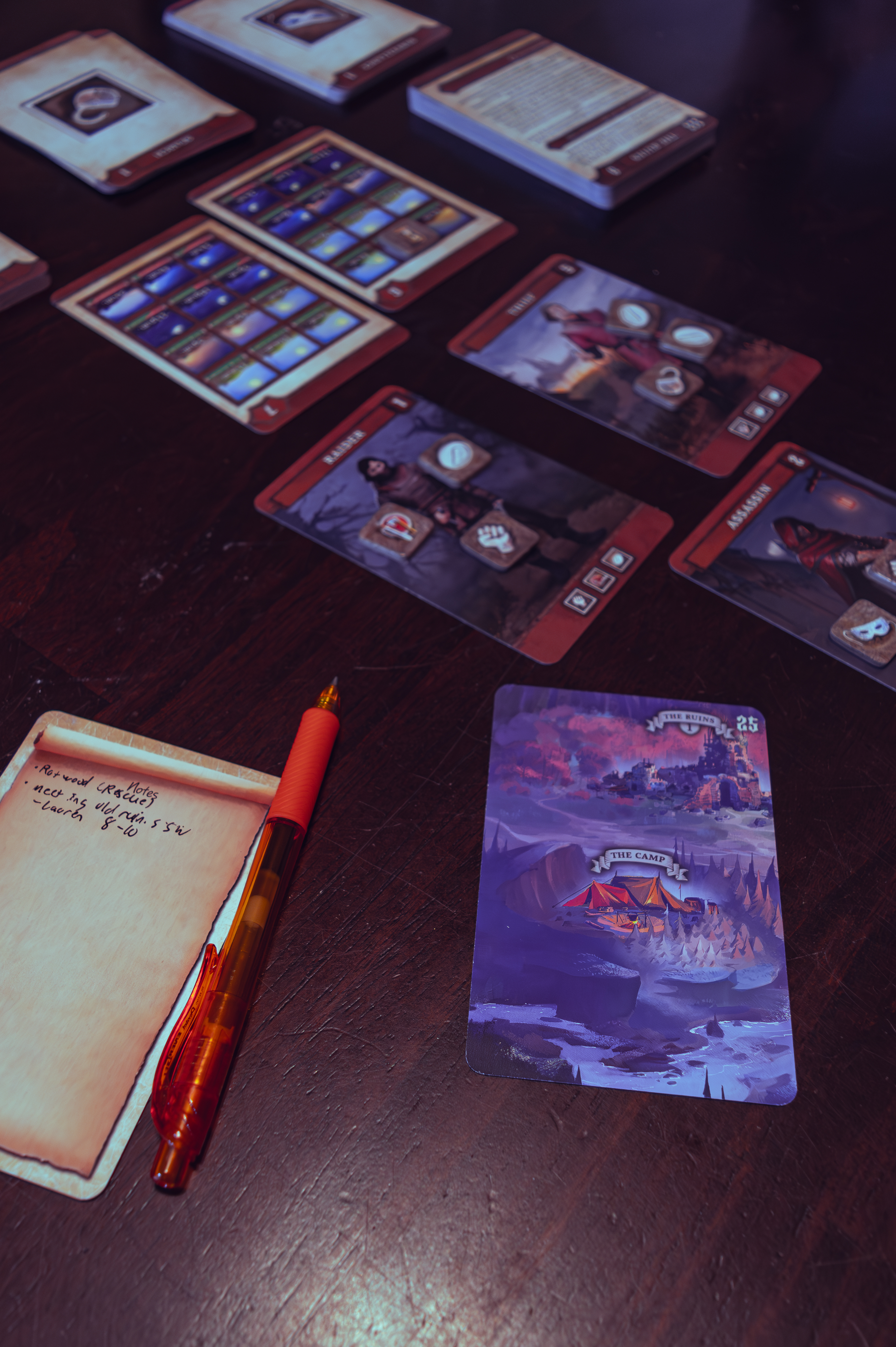 Cards from "Mortum: Medieval Detective" displying notes, a map piece, and character cards. 