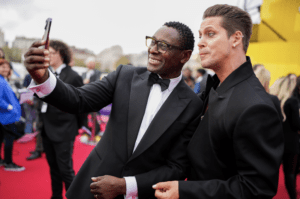 two men taking a photo on the red carpet 