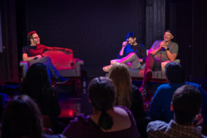 picture of three men talking on stage