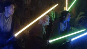 Jedi stand with their lightsabers out.