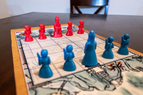 Onitama board game pawns at play on the game mat