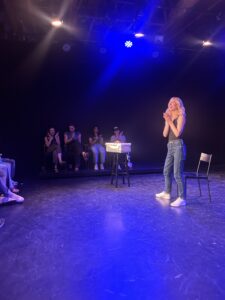 picture of a woman on stage at a black box theater 