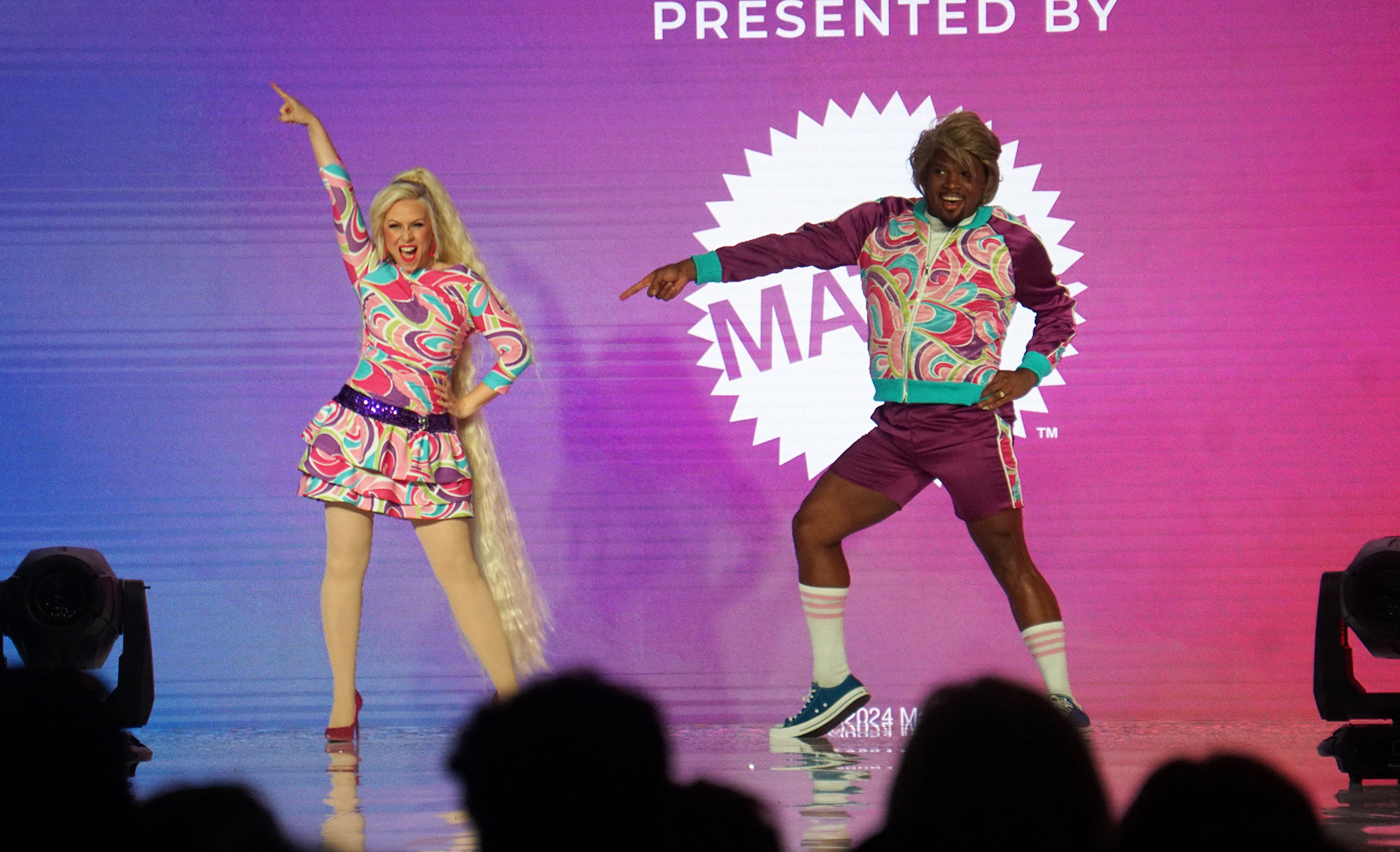 Hosts Ashley Eckstein and Michael James Scott in Totally Hair Barbie and Ken inspired fashion at the Her Universe Fashion Show 2024.