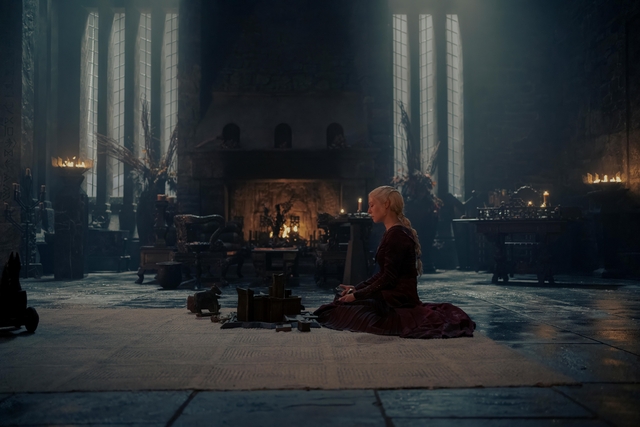 rhaenyra targaryen on the floor holding her youngest sons wooden toy 