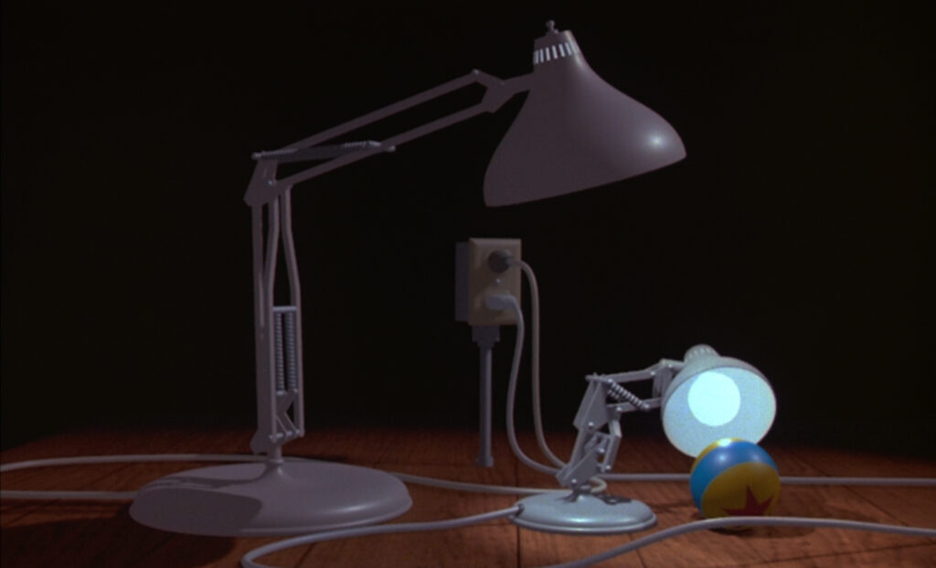 Two white, angular desk lamps- one bigger and the "parent" the other smaller and the "junior"- look at a yellow and blue striped ball with a red star on it.