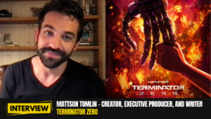 A photo of Mattson Tomlin with a poster of Terminator Zero