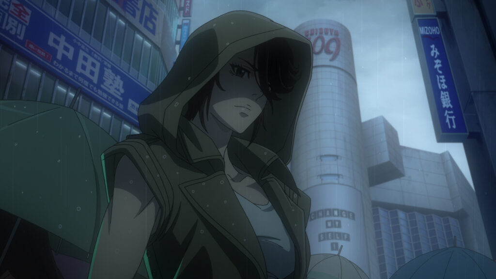 Eiko in Japan, wearing a sleeveless vest with a hood to hide her face