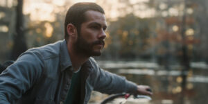 Paris drives a motor boat on Caddo Lake. He looks off to the right.