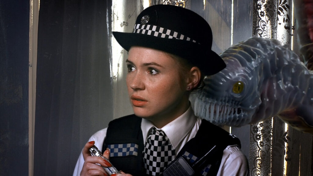 Prisoner Zero, a large translucent worm-like creature with yellow eyes and sharp teeth, is just behind Amy Pond.