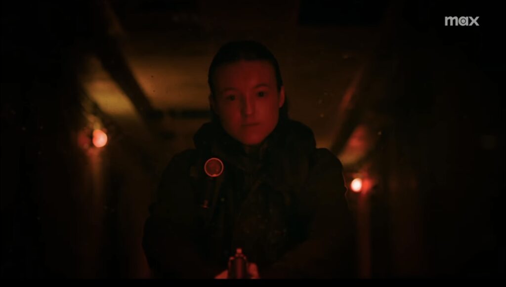 Ellie stands in a dark hallway, highlighted in red, holding a gun.