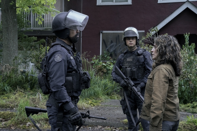 Isaac in a FEDRA uniform stands before a woman who is part of the resistance.