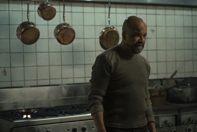 Isaac stands in an old restaurant kitchen.