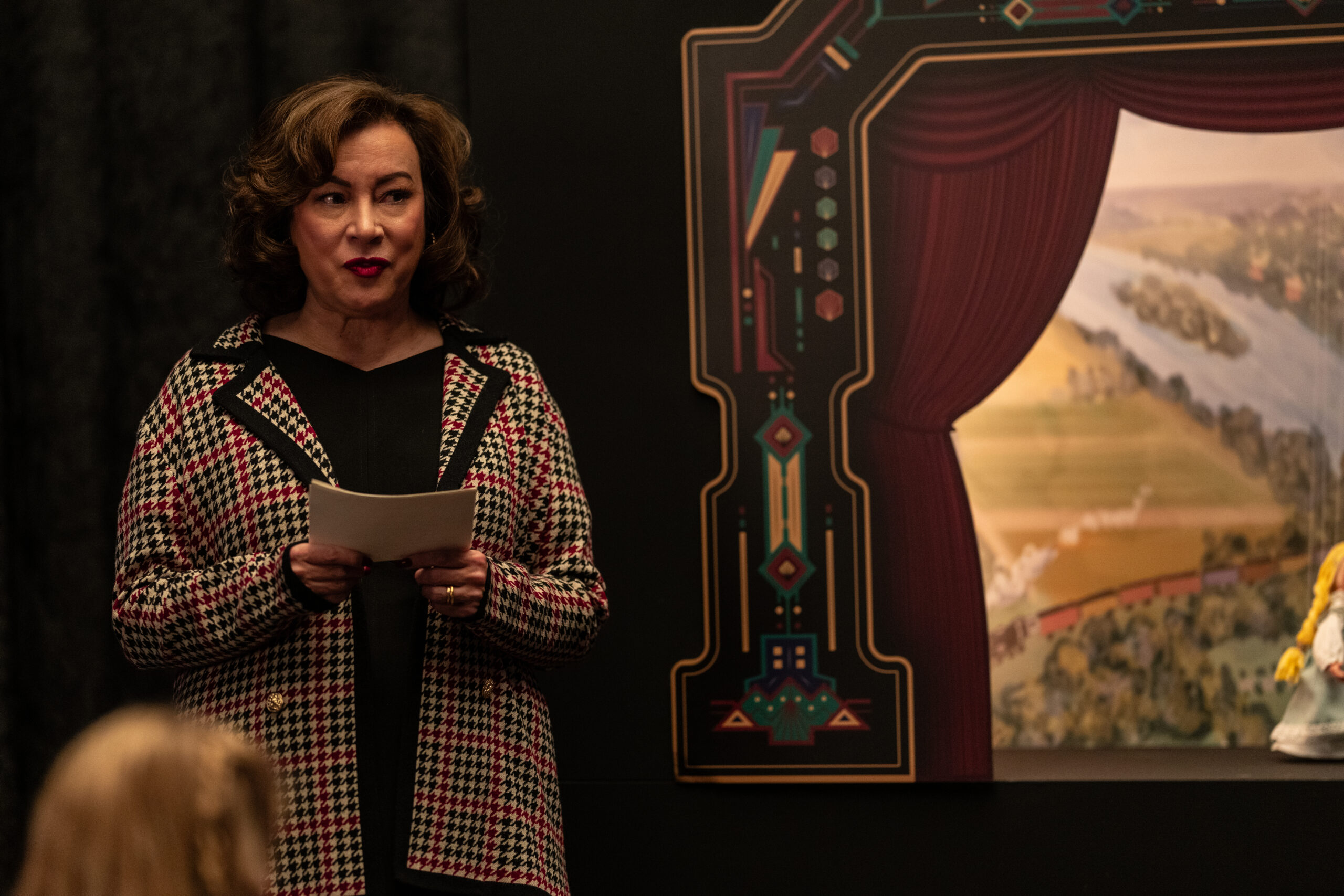 Dr. Deborah Hunter-Price is narrating a puppet show at the festival their having at the school in School Spirits Season 3.